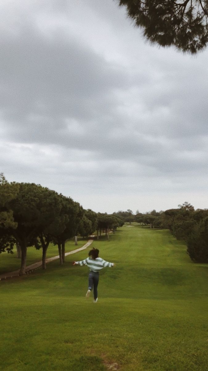 a person running across a lush green field