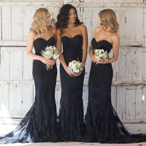 three women in black dresses standing next to each other with bouquets on their laps