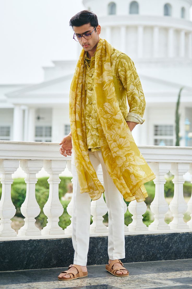 Lime yellow silk bundi with pintucked mandarin collar, patch pockets and all over floral print. Paired with printed full sleeve shirt and off white trousers with side pockets.
Components: 3
Pattern: Printed
Type Of Work: Floral Print
Neckline: Mandarin Collar
Sleeve Type: Bundi: Sleeveless, Shirt: Full Sleeves
Fabric: 100% Silk
Color: Yellow
Other Details: 
Apple hem
Closure:
Bundi: Front buttons
Trouser: Front concealed zip, hook and eye
Note: The dupatta worn by the model is not for sale
Occas Western Outfit Men, Floral Menswear, Resort Wear Men, Ethnic Trends, Indian Wedding Clothes For Men, Wedding Outfits For Groom, Haldi Outfits, Gents Kurta Design, Gents Kurta