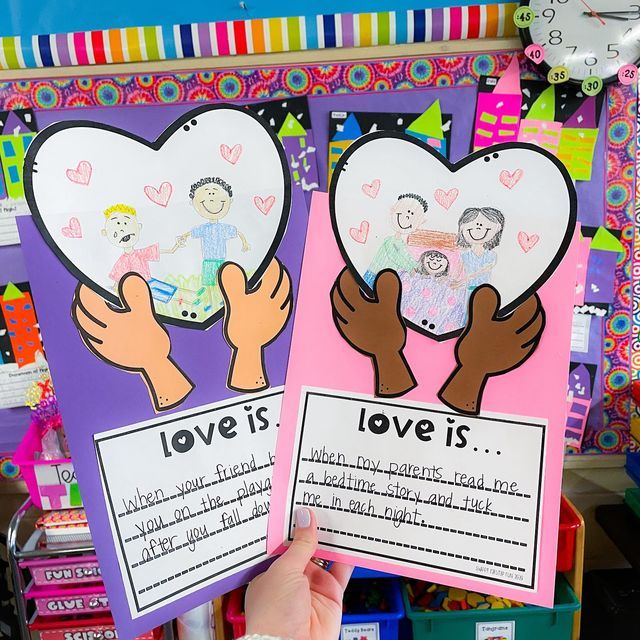 hands holding up two posters with children's drawings on them and the words love is