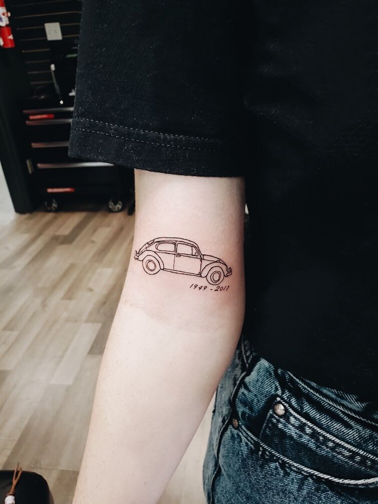 a person with a small tattoo on their arm that has a car drawn on it