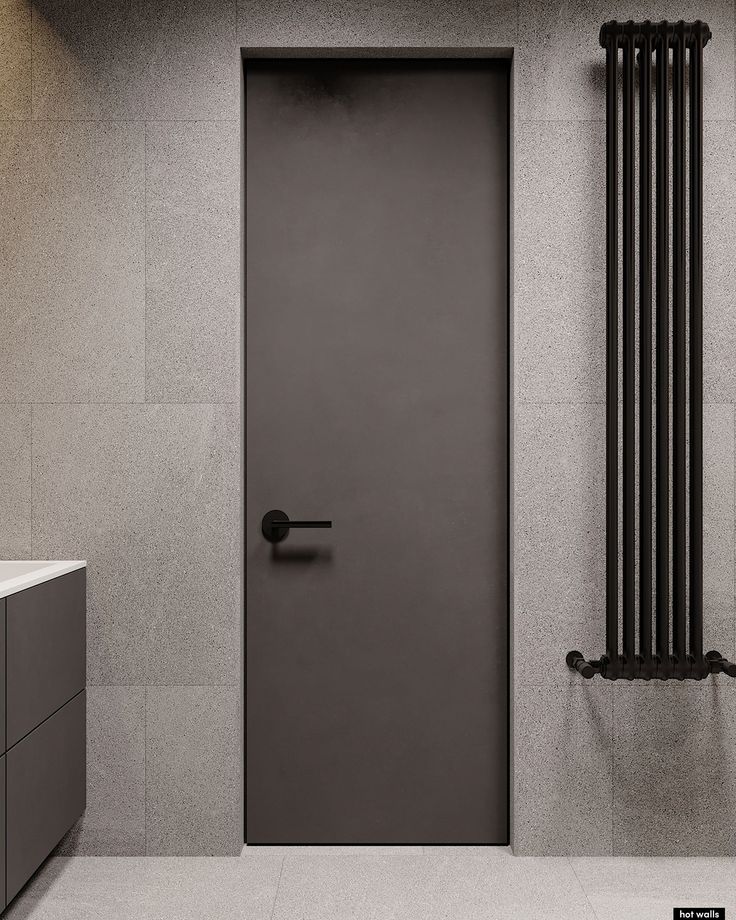 an empty bathroom with a gray door and radiator