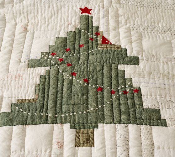 a quilted christmas tree with red stars on it's top and bottom corner