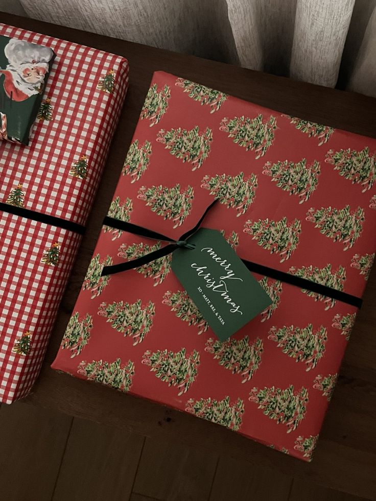 two wrapped presents sitting on top of a wooden table