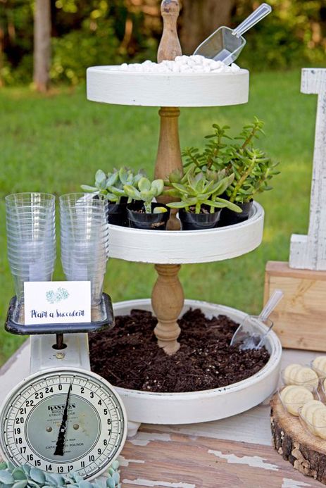 a table topped with three tiered planters filled with succulents and plants