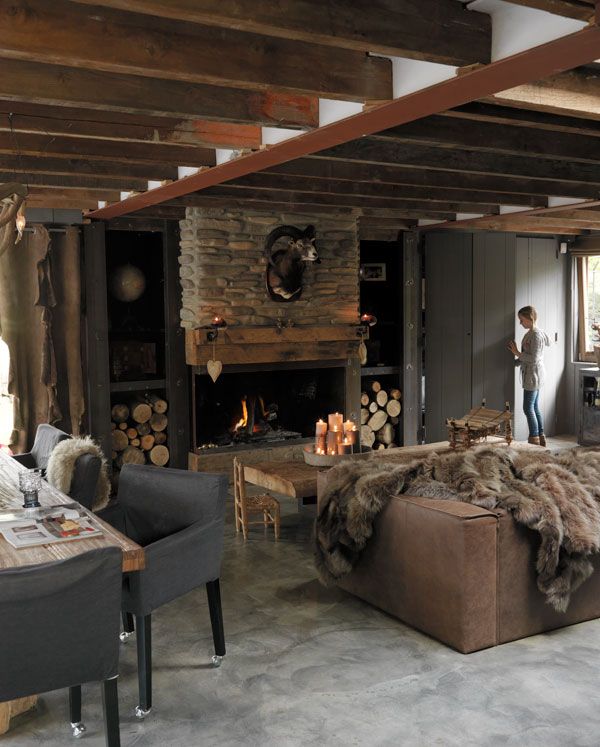 a living room filled with furniture and a fire place in the middle of a room