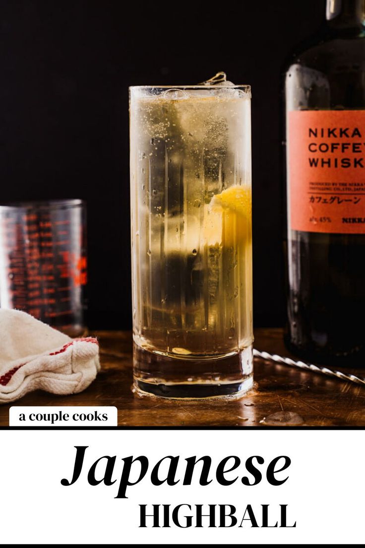 a glass filled with liquid next to a bottle of japanese highball tea on a wooden table