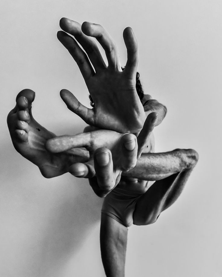 black and white photograph of hands reaching up to grab something