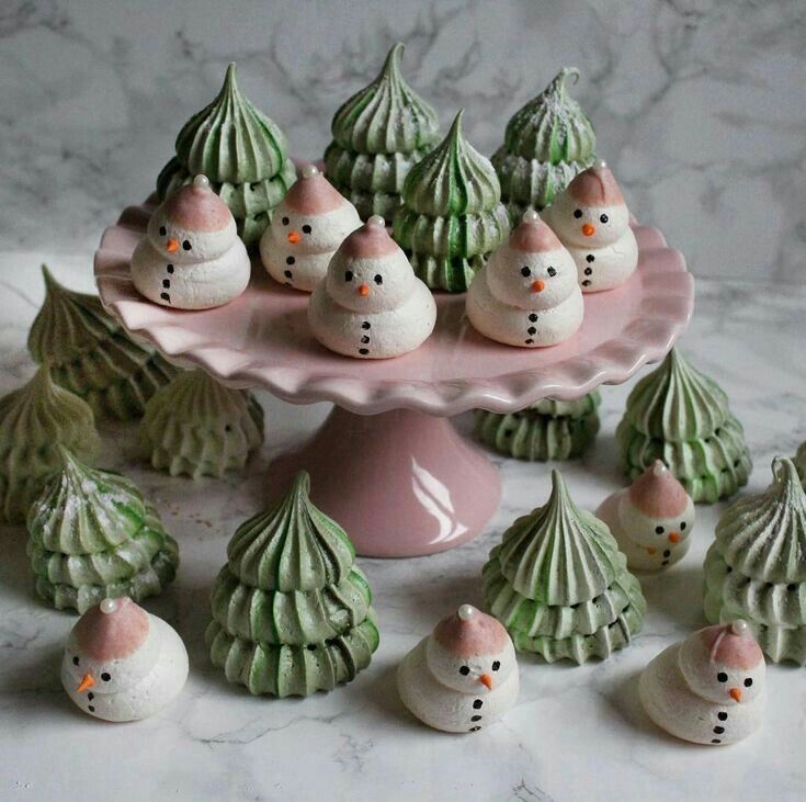 there are many small snowmen sitting on the cake platter with little seashells