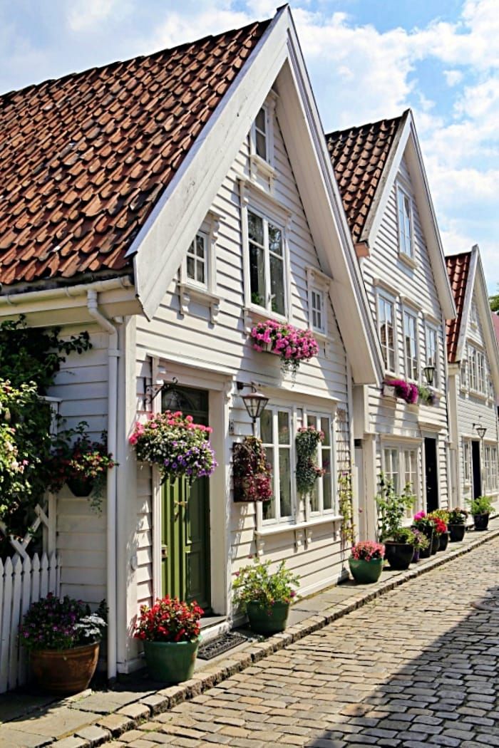 a row of white houses with flower boxes on the front and side of each building