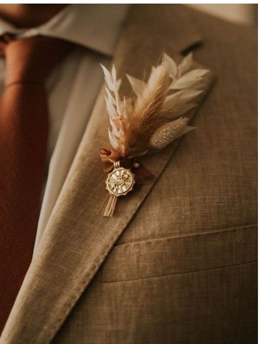 a man wearing a suit and tie with feathers on it's lapel pin