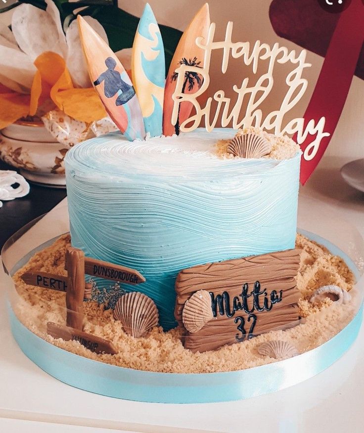 a birthday cake made to look like a beach scene with surfboards and sand on top