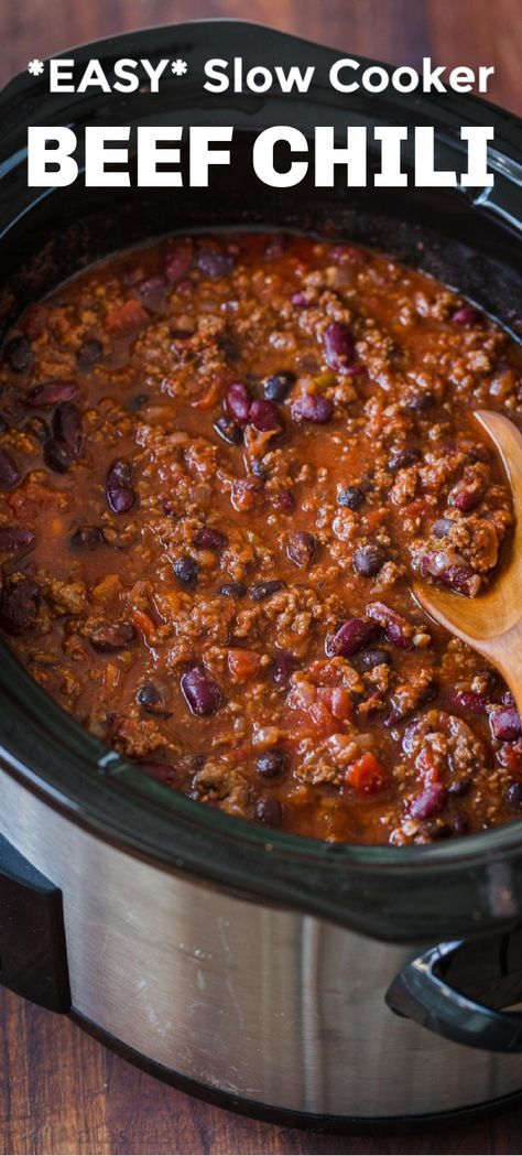 a slow cooker filled with beef chili and topped with a wooden spoon in it