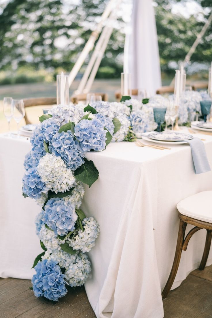 the table is set with blue and white flowers