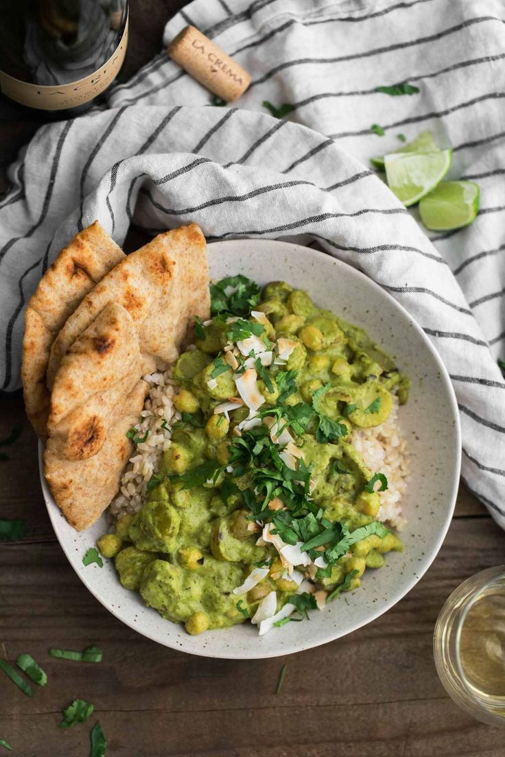 a white bowl filled with rice and guacamole next to pita bread