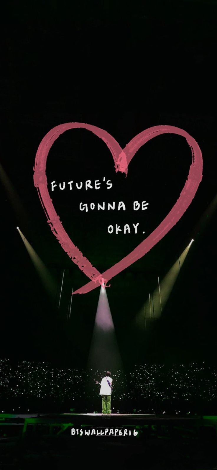 a man standing on top of a stage under a heart shaped sign that says future's gonna be okay