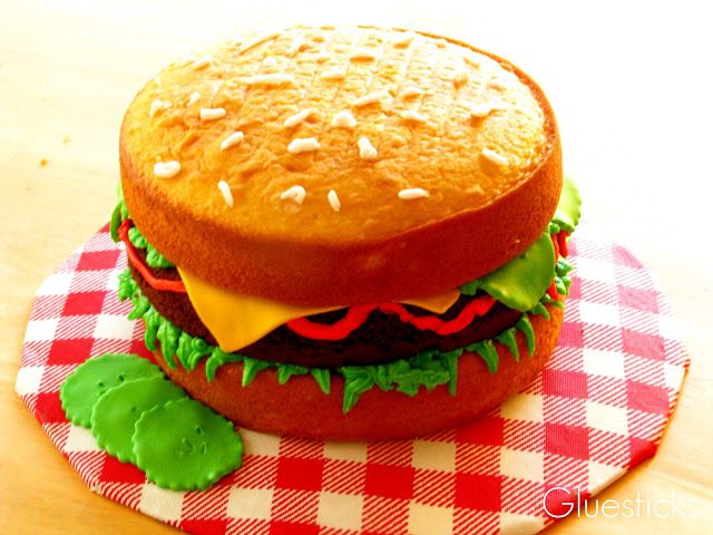 a hamburger sitting on top of a red and white checkered tablecloth covered plate