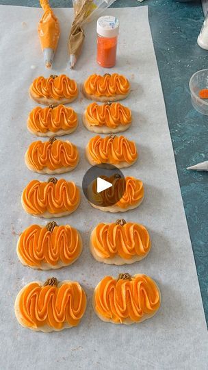 some orange cookies are on a table and ready to be decorated