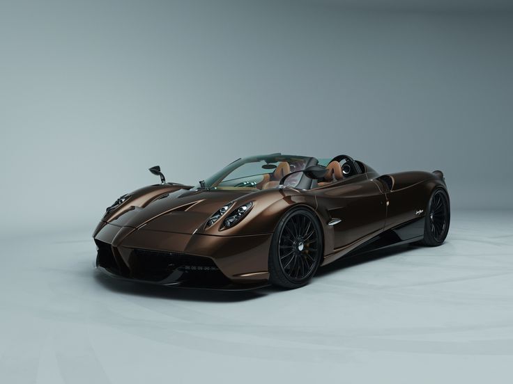 a brown sports car is parked in a studio area with the top down and it's hood up