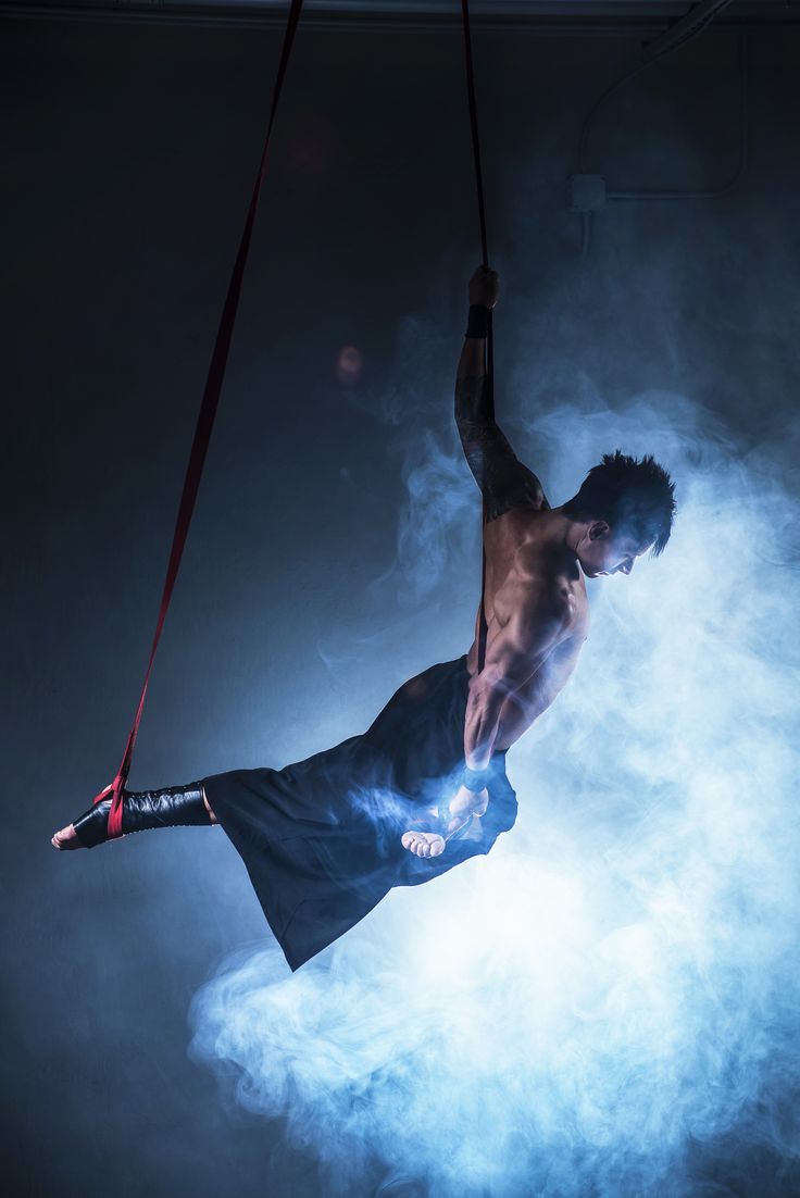 a man is suspended in the air on a rope with his hands and legs extended