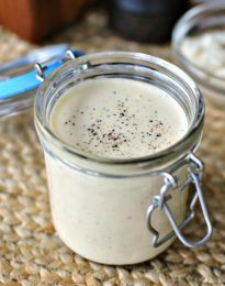 a glass jar filled with white liquid sitting on top of a table