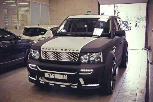 a range rover parked in a showroom with other cars