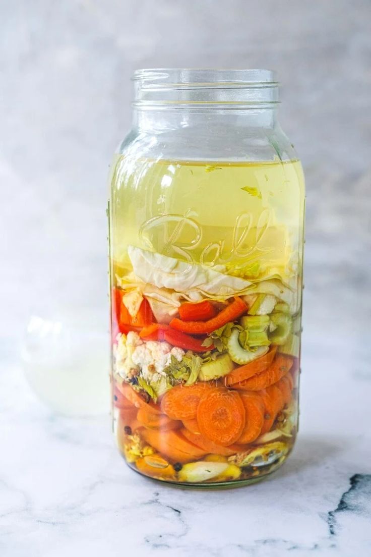 a jar filled with vegetables sitting on top of a table