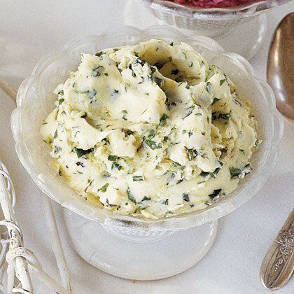 a bowl filled with mashed potatoes on top of a table next to silverware