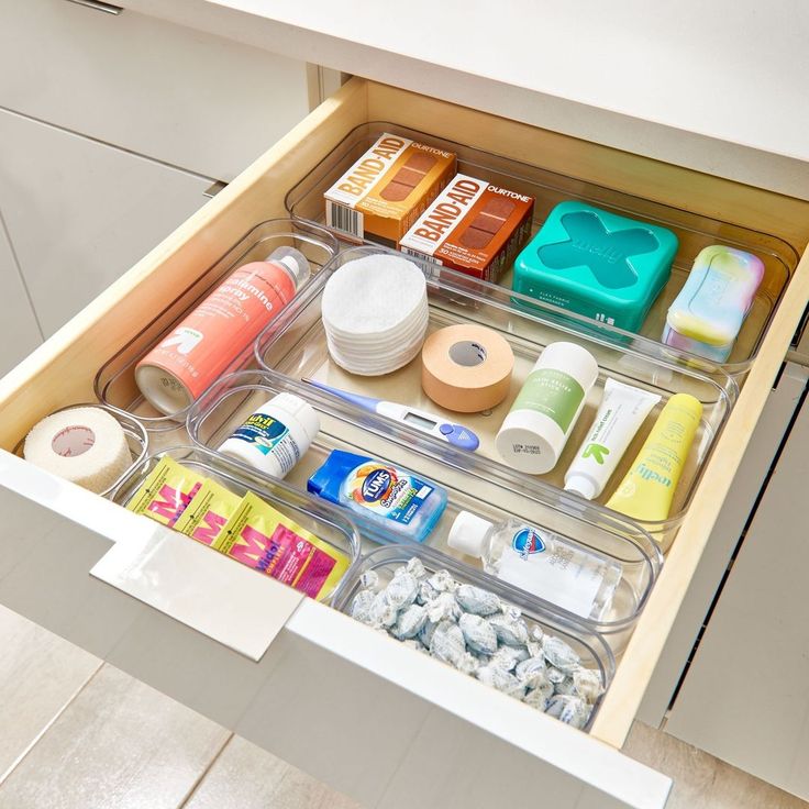 an open drawer with various items in it and on the bottom shelf are toiletries