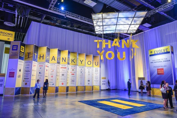 a group of people standing in front of a thank you sign on a stage at an event