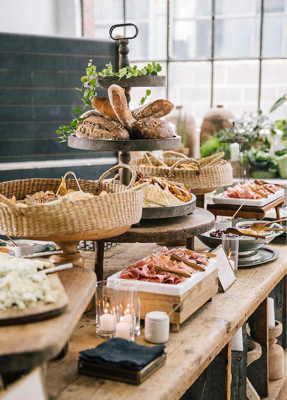 an assortment of breads and pastries on a table in a room with large windows