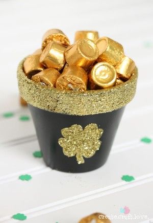 a black cup filled with gold foil shamrocks