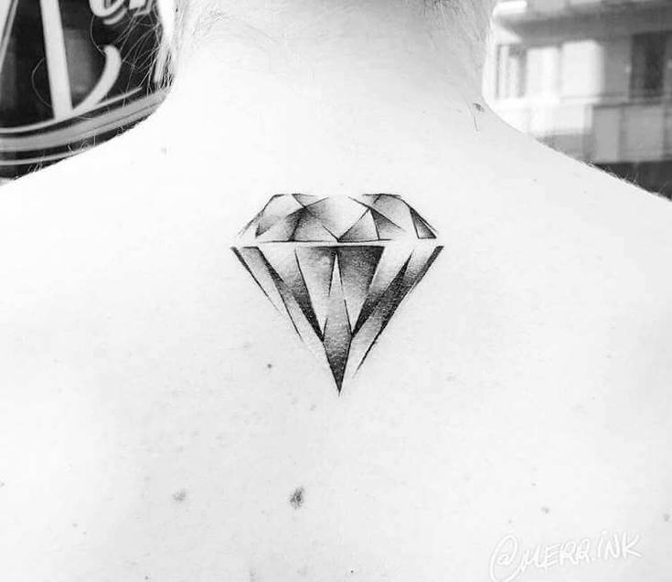 a black and white photo of a woman's back neck with a diamond tattoo on it