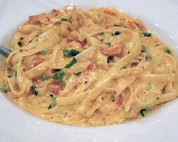 a white plate topped with pasta covered in sauce