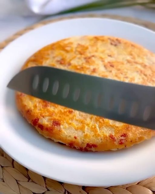 a pizza on a plate with a knife stuck in it