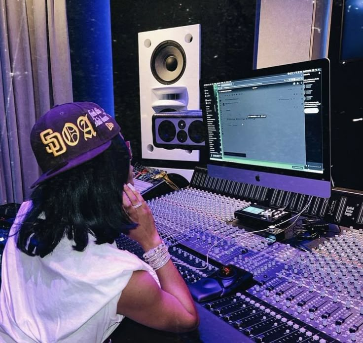 a person sitting in front of a mixing desk