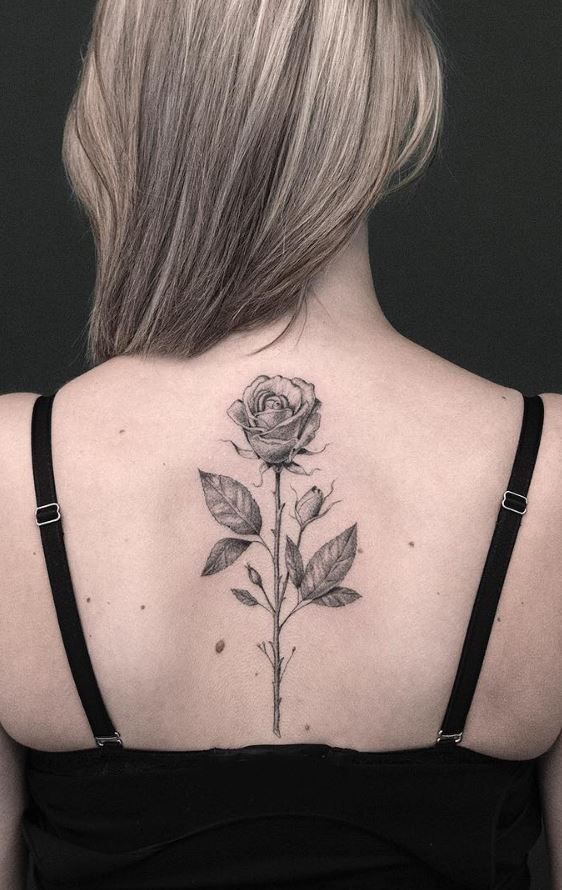 a woman with a rose tattoo on her back