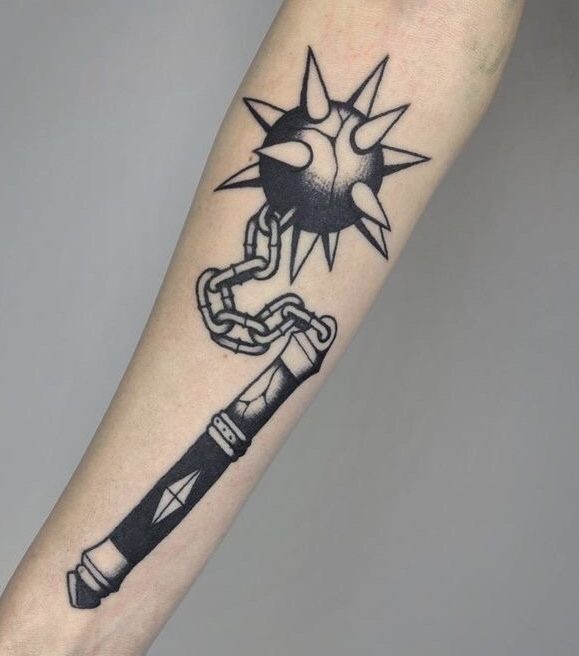 a black and white tattoo on the arm of a person with a chain around it