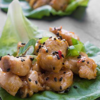 some type of food that is on top of a green leafy plate with lettuce