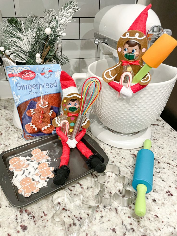 the elf is baking cookies on the counter next to other holiday treats and decorations, including gingerbreads