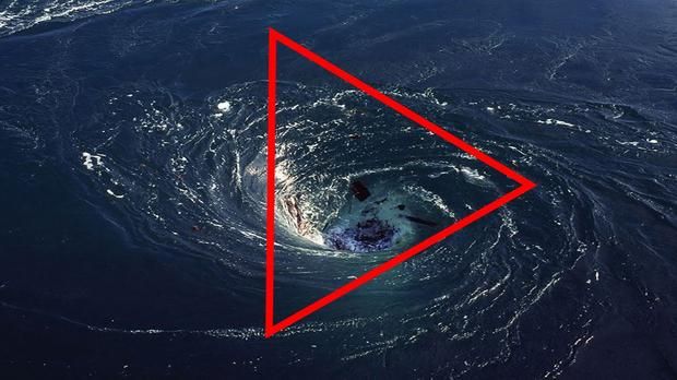 a red triangle in the middle of a blue ocean with a white object on it