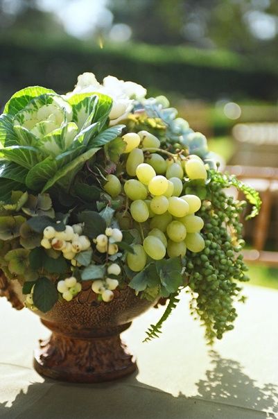 a vase filled with lots of green and white flowers