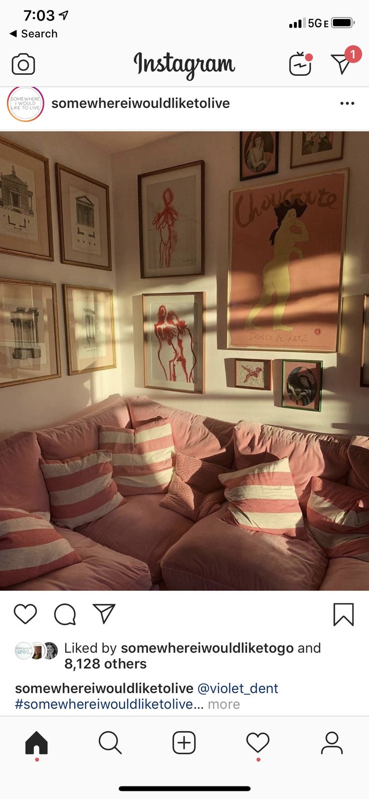 an instagram photo of a living room with pink couches and pictures on the wall