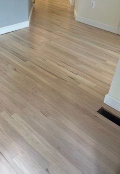 an empty living room with hard wood floors