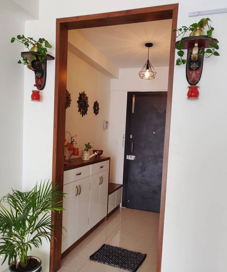 an entry way leading to a kitchen with potted plants