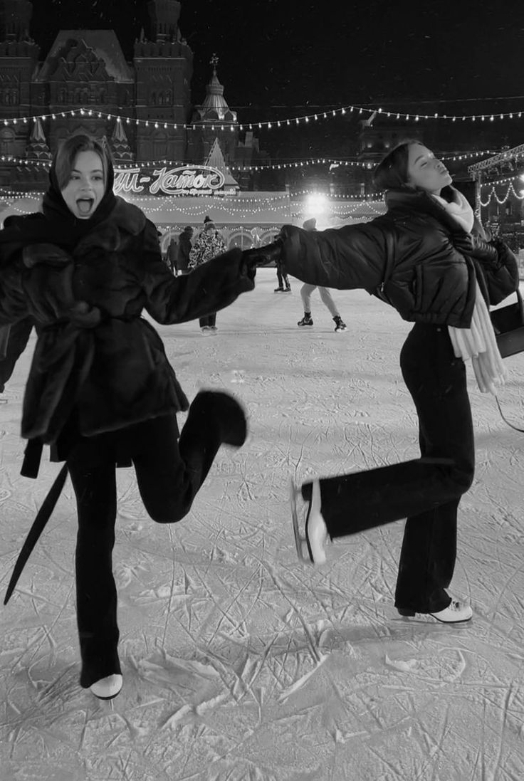 two women are playing in the snow at night