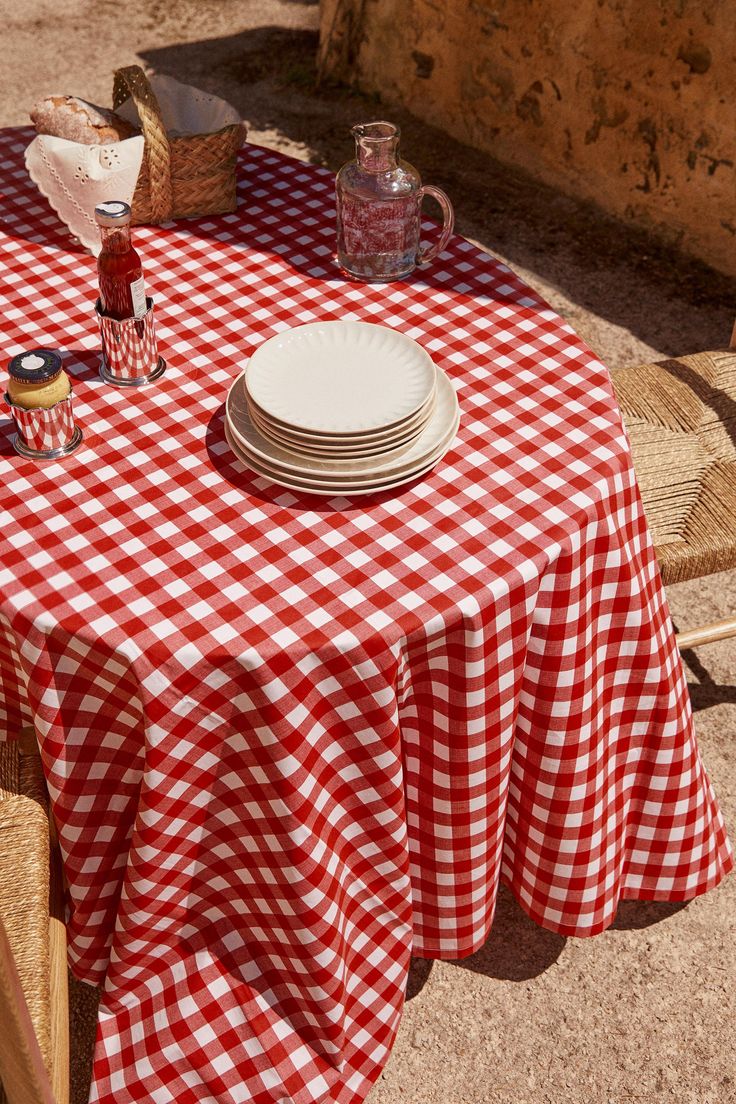 a red and white checkered table cloth with plates on it