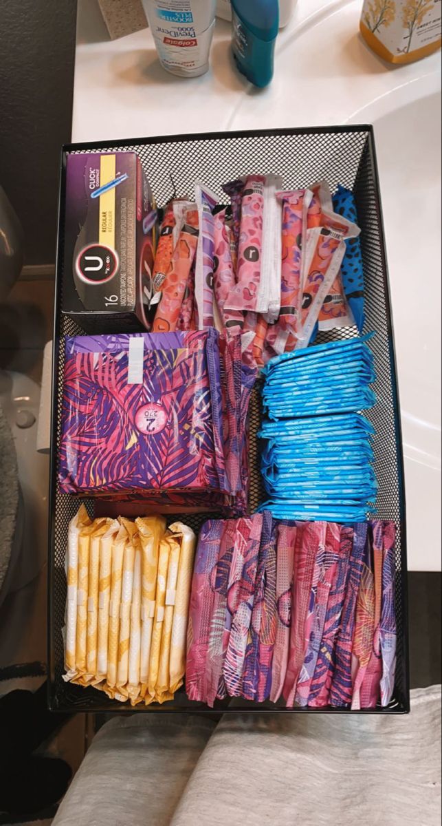 an open suitcase filled with lots of different types of wrapping paper and toiletries next to a sink