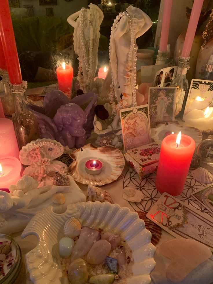 a table topped with lots of candles and seashells