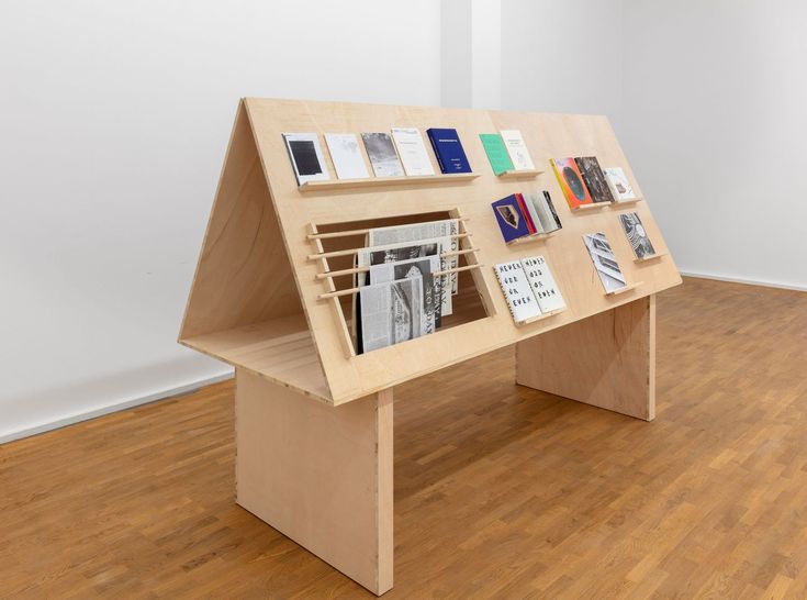 a wooden table with books on it in the middle of a wood floored room